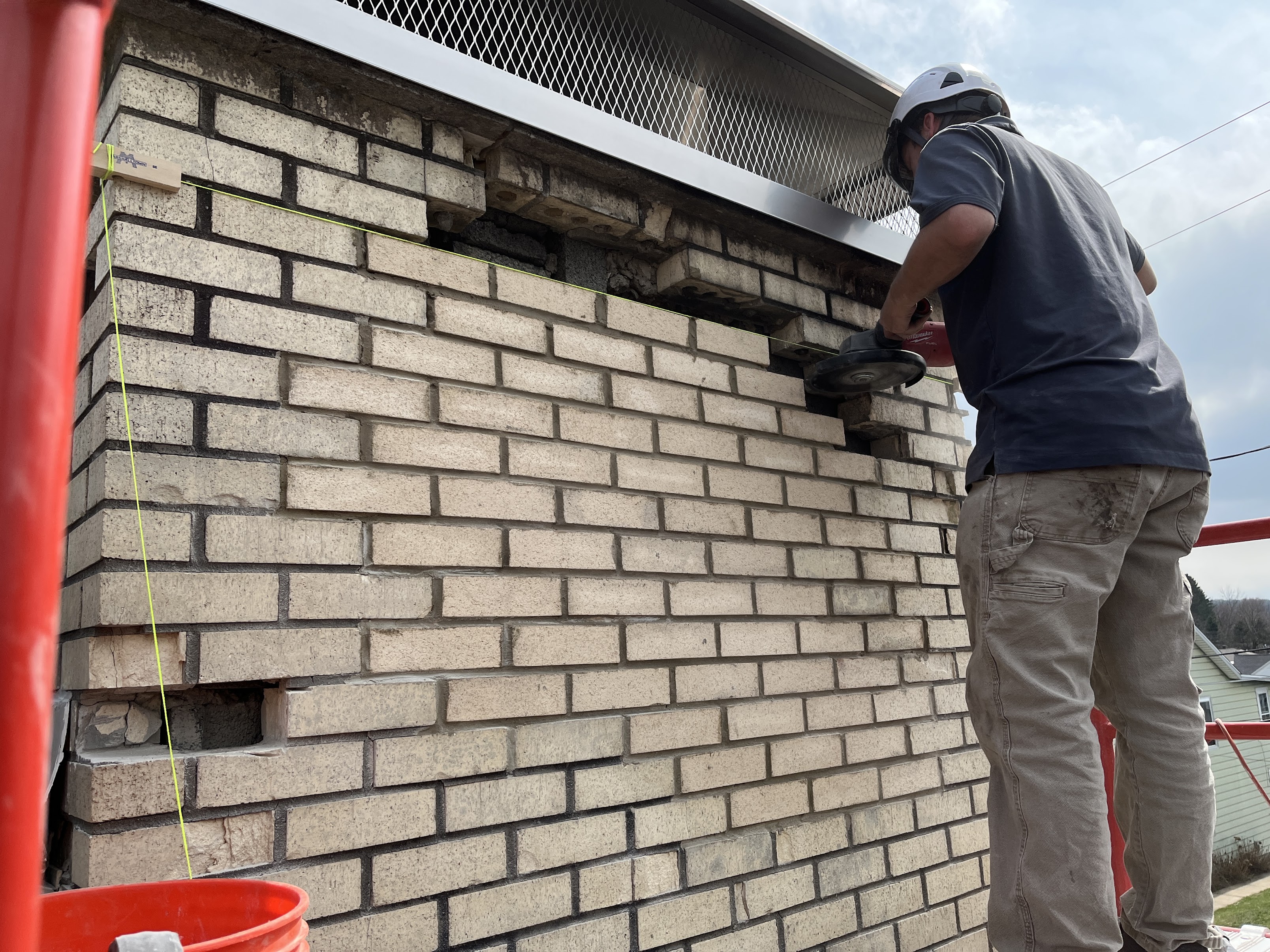 Brick chimney showing exterior repair work in progress.