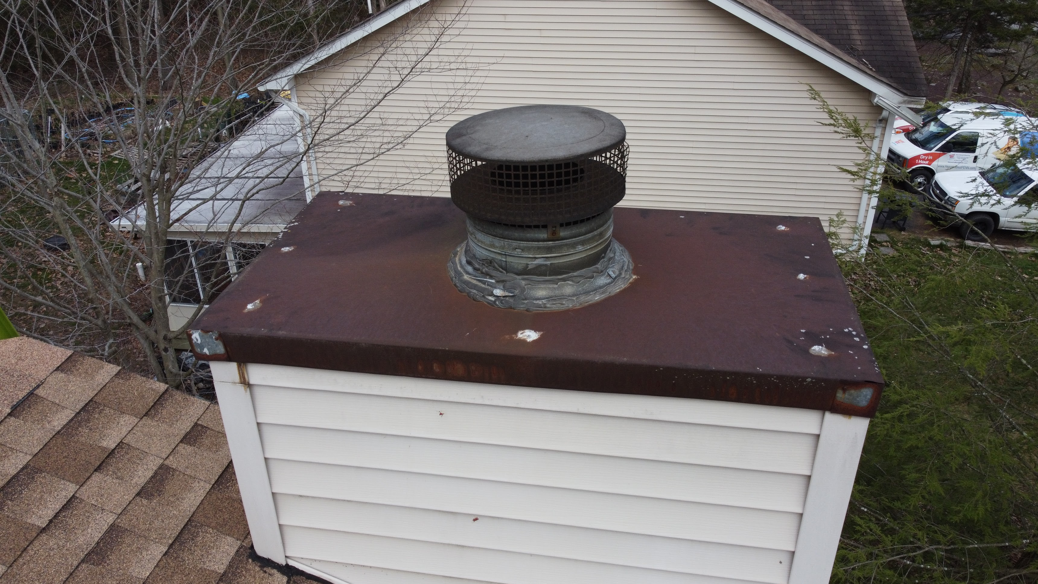 Rusted chimney chase cover showing wear.